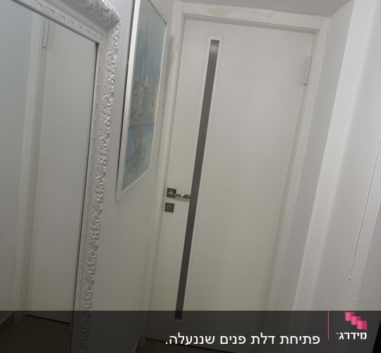 דלת לבנה עם ידית מתכת במסדרון צר